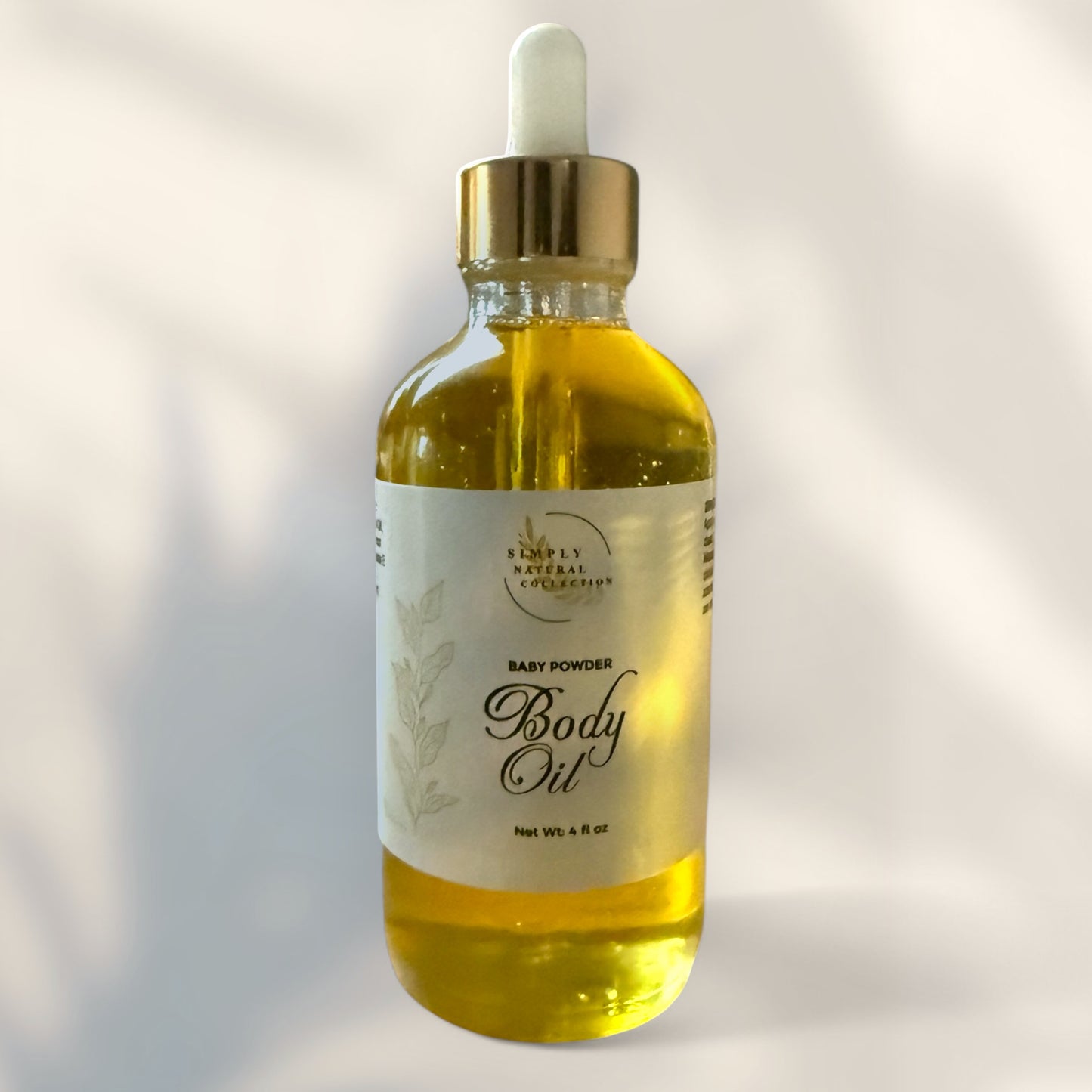 Bottle of baby powder body oil with dropper on a light background