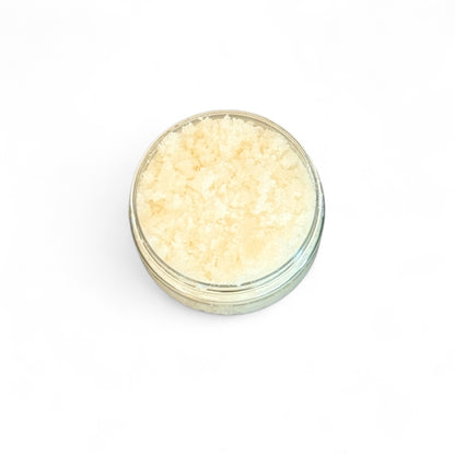 Small glass jar filled with light-colored Peaches and cream body scrub  on a white background